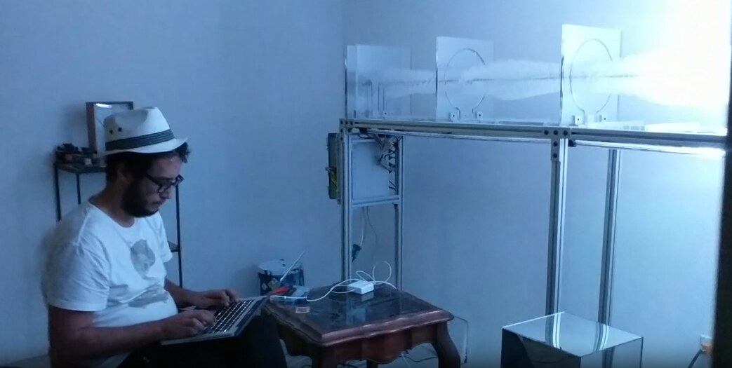 at the laptop in front of the acrylic modules, mid-build